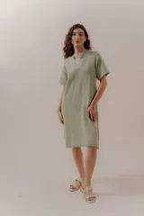 Vestido tejido color verde claro, con escote en V, mangas cortas y aberturas laterales.