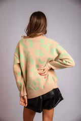 Sweater de punto color crudo con estampado animal print marrón.