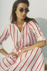 Camisa a rayas verticales blancas y negras, de corte recto y mangas largas.