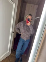 Cardigan de punto grueso color gris jaspeado, con cuello alto y mangas largas.
