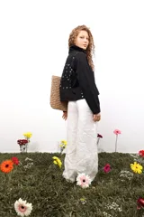 Chaqueta marrón de algodón con botones metálicos, cuello clásico, bolsillos frontales y apliques de tachas y botones formando una flor en la espalda.