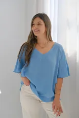 Blusa celeste de lino con escote en V y mangas cortas amplias.