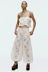 Pantalón bombacho de encaje color crudo, tiro alto, cintura elástica y forro interior.