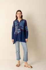 Túnica azul con bordados florales, cuello camisero y botones forrados.