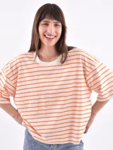 Remera de corte holgado con mangas cortas, a rayas horizontales blancas y naranjas.