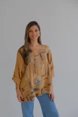 Blusa color ocre con estampado abstracto en tonos marrones y grises. Tiene cuello redondo y mangas 3/4 con botón.