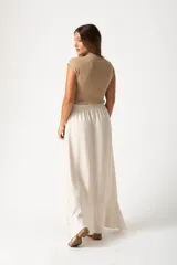 Falda larga color beige con cintura elástica y volados asimétricos.