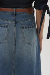 Falda larga de jean celeste con corte evasé, tiro medio y detalles bordados en el frente.