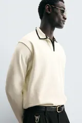 Polo color crema de corte relaxed fit, con cuello solapa con abertura frontal y manga larga. Presenta bordado combinado a contraste en cuello y acabados en rib.