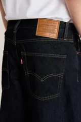 Pantalón de jean azul oscuro, corte amplio, con bolsillos delanteros y traseros.