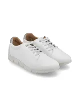 Sneaker de cuero blanco con talón dorado, cordones finos y suela beige con diseño anatómico.