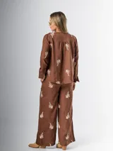 Conjunto de camisa y pantalón marrón chocolate con bordados en hilo crudo. El pantalón lleva elástico en la cintura.