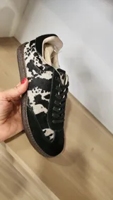 Zapatillas urbanas con estampado animal print en blanco y negro, detalles en gamuza negra y cordones negros. Incluye cordones crudos extra.