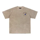 Remera oversize color beige con efecto gastado, cuello redondo y estampado pequeño en el pecho con el logo de la marca Kaboa Industries y la frase 'Más barrio que moda'.