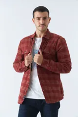 Sobrecamisa de algodón para hombre con interior de corderito, estampado a cuadros en tonos negro, blanco y azul. Tiene cierre de botones, bolsillos tipo cartera y logo en goma. El modelo usa talle M.