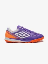 Championes de fútbol Umbro modelo Adamant, color violeta con detalles en naranja y blanco. Presentan un diseño texturizado en la puntera y el logo de Umbro en los laterales.