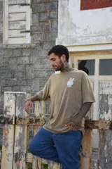 Remera blanca de algodón con cuello redondo y manga corta. Estampado pequeño en el frente de una mano haciendo el signo de la paz en color celeste.