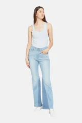 Pantalón de jean celeste con corte flare y diseño de parches en diferentes tonos de azul.