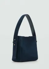 Bolso de mano marrón de piel serraje con asa corta ajustable y asa de hombro. Tiene forro interior, cierre de botón magnético y tamaño mediano.