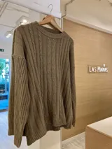 Sweater color marrón claro de tejido de punto con diseño de ochos en el frente y mangas con diseño a rayas verticales.