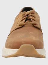Sneakers marrones de cuero con cordones y suela blanca texturizada.