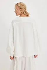 Camiseta de manga larga color verde oliva, con textura acanalada y silueta holgada extragrande. Presenta escote redondo, hombros caídos y puños anchos.