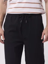 Pantalón de vestir blanco, de corte recto, con cintura elástica tipo jogger y bolsillos laterales.