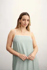 Vestido largo color verde agua, de corte suelto y breteles finos blancos.