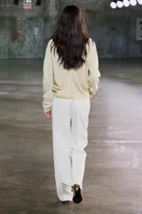 Cárdigan color crema de punto fino con escote en pico, cierre frontal con botones y manga larga.