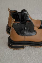 Botas Chelsea color marrón con paneles laterales elásticos y suela track.