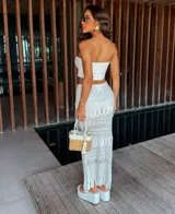 Vestido tejido strapless color blanco, con detalles calados y falda larga con flecos. Incluye short.