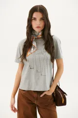 Remera blanca con estampado de moldes de costura en color marrón.
