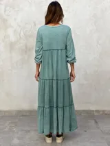 Vestido largo color morado, con escote en V, mangas largas y corte escalonado.