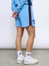 Short deportivo azul marino con ribetes blancos y rojos, y escudo del Club Nacional de Football bordado en la pierna derecha.