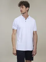 Polo de piqué azul marino, de corte clásico, con cuello abotonado y mangas cortas.