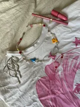 Collar corto con cuentas de perlas sintéticas y dijes de conejitos y flores de colores.