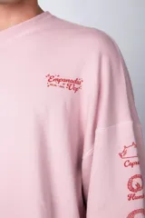 Buzo negro de corte oversize con cuello redondo y mangas largas. Presenta un pequeño logo estampado en el pecho y un diseño de empanadas y textos en la manga.