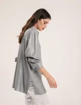 Camisa oversized con terminación metalizada, botones a tono y tajos a los costados.