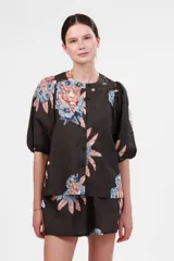 Camisa de manga corta abullonada con cuello mao y estampado de tigres y flores en tonos naranja, azul y rosa sobre fondo gris.