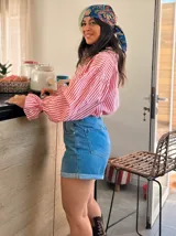 Camisa de organza a rayas verticales rojas y blancas, con mangas largas abullonadas y puños elásticos.