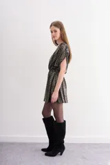 Vestido corto con escote cruzado en V y manga corta, confeccionado en tul con tejido de rayas doradas y negras. Presenta un lazo para ajustar la cintura y un viso interior con breteles regulables.