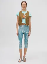 Chaleco marrón de denim con apliques metálicos y flecos en el ruedo.