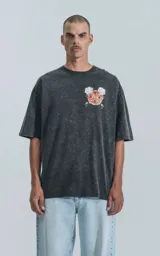Remera negra con efecto acid wash, corte holgado y estampa frontal con diseño alusivo a Disney.