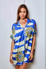 Camisola estampada en seda, con cuello camisero, manga corta y calce holgado. Presenta un diseño con rayas horizontales y flores. Puede usarse como camisa o vestido.