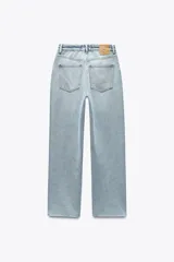 Pantalón de jean color crudo, de tiro alto, corte recto y largo tobillero. Tiene cinco bolsillos, cierre frontal con cremallera y botón metálico.