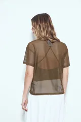 Top de manga corta de tejido mesh (tipo red) color verde militar, con calce relajado y nudo frontal. Se sugiere usar sobre otra prenda debido a su transparencia.