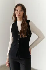 Chaleco gris de tejido de punto con cuello en V, cierre frontal con botones y bolsillos delanteros.