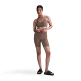 Top deportivo Nike Indy Light Support color chocolate, con logo en la banda inferior. Ideal para entrenamiento de bajo impacto.