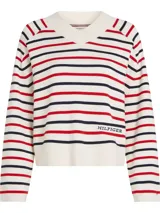Sweater de punto color crema con rayas horizontales rojas y azul marino. Tiene cuello en V, mangas largas y logo de Tommy Hilfiger bordado en el pecho.