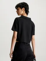 Remera negra corta de punto canalé con cuello tipo chomba y corte holgado.